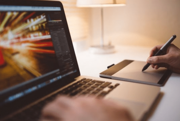 Startup founder working on startup on Mac and notepad.