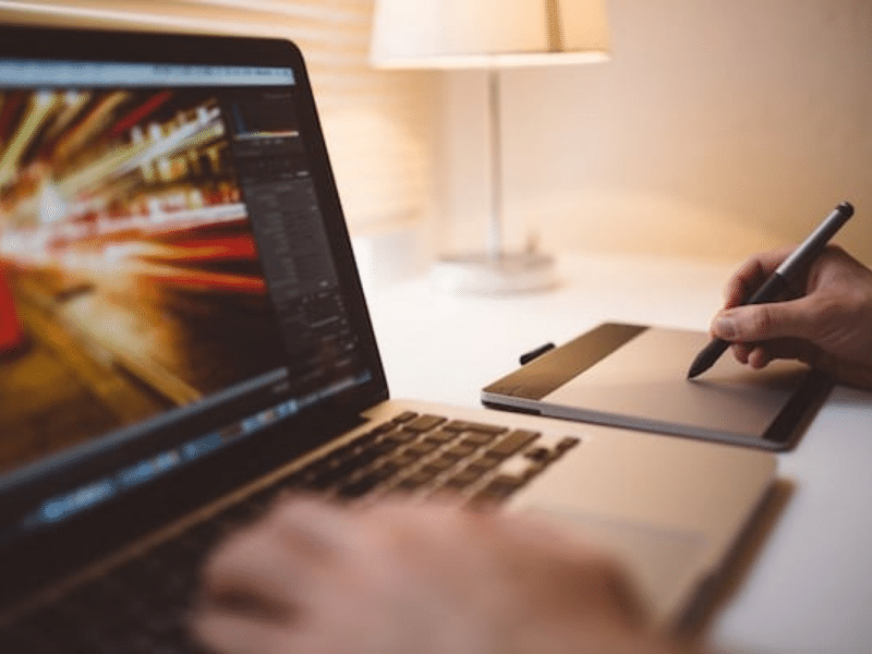 Startup founder working on startup on Mac and notepad.